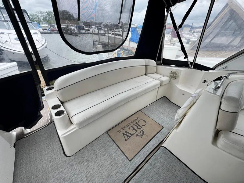 Slide: The Image of 2006 Rinker 342 Express Cruiser interior with white seating and marina view. - 9