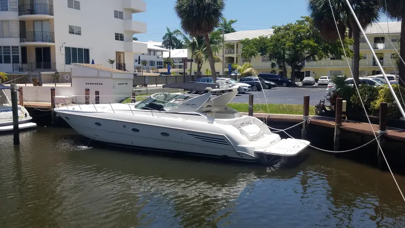 The Image of 1999 Trojan 440 Express Yacht docked in a sunny marina setting. - 1
