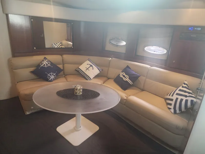 Slide: The Image of Luxurious interior of 1999 Trojan 440 Express Yacht with plush seating and nautical-themed pillows. - 3