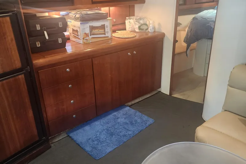 Slide: The Image of Interior of 1999 Trojan 440 Express Yacht with wooden cabinetry and blue rug. - 4