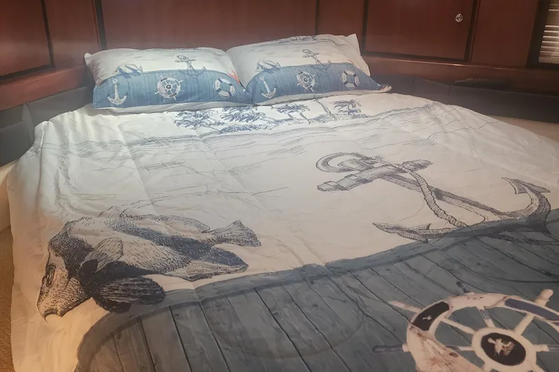 Slide: The Image of Nautical-themed bedding in a 1999 Trojan 440 Express Yacht cabin. - 7