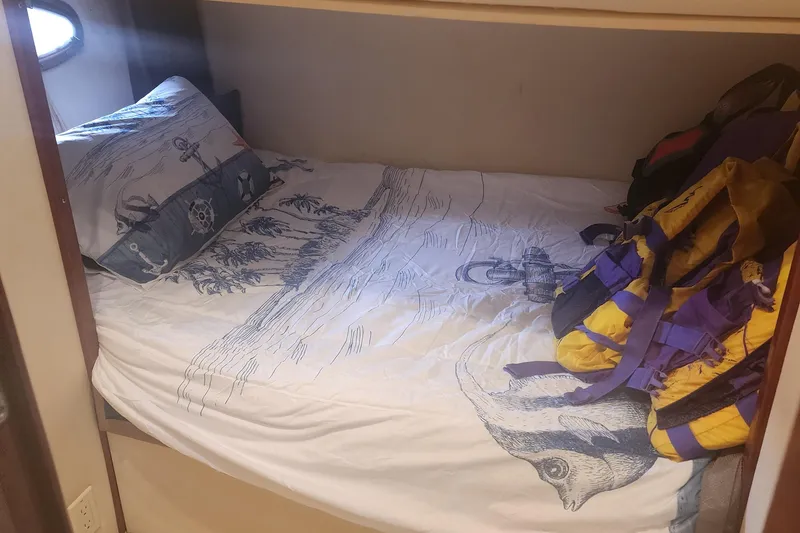 Slide: The Image of Cozy cabin bed in 1999 Trojan 440 Express Yacht with nautical-themed bedding. - 8