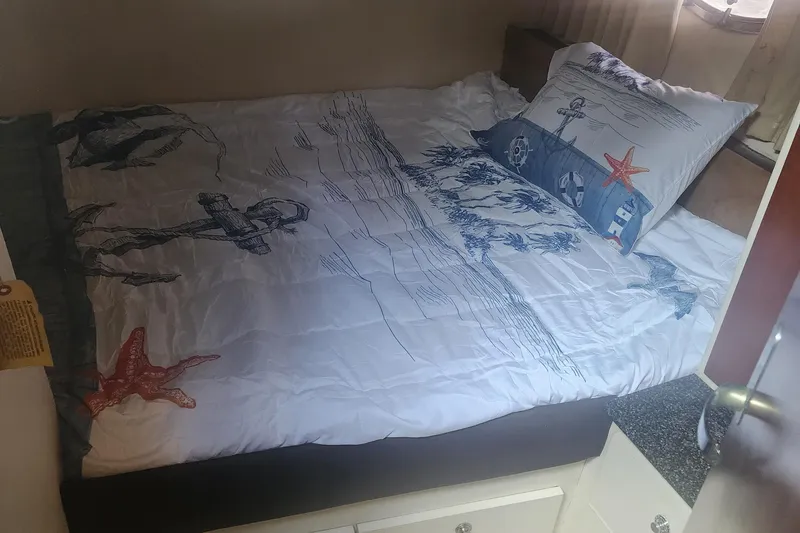Slide: The Image of Cozy bedroom in 1999 Trojan 440 Express Yacht with nautical-themed bedding. - 9