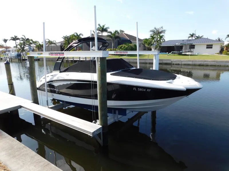 Slide: The Image of 2017 Chaparral 244 Sunesta boat docked on a lift in a canal setting. - 1