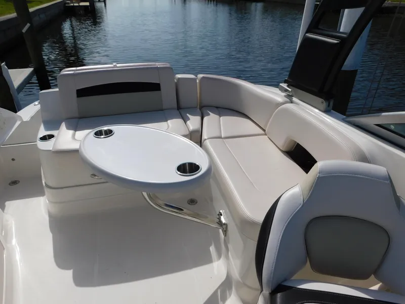 Slide: The Image of 2017 Chaparral 244 Sunesta boat interior with seating and table by the water. - 10