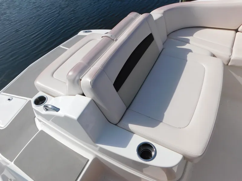 Slide: The Image of 2017 Chaparral 244 Sunesta boat seating area with cup holders, on calm water. - 11