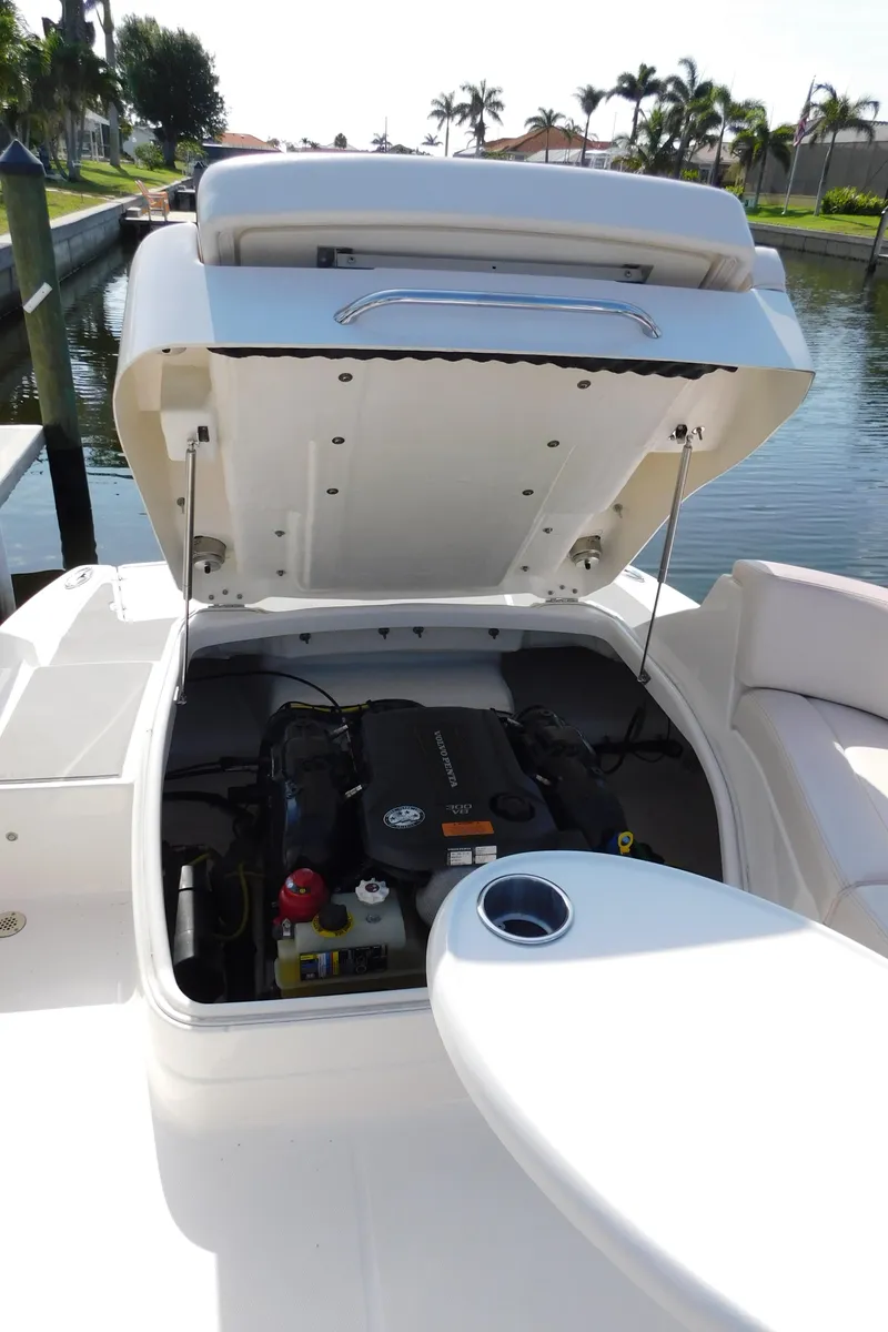 Slide: The Image of 2017 Chaparral 244 Sunesta boat engine compartment open by the water. - 19