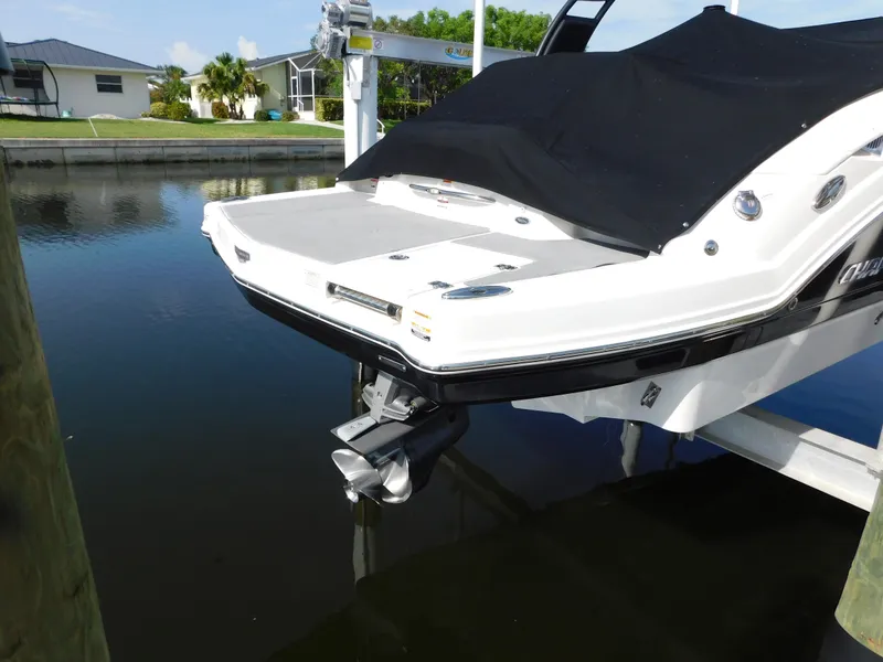 Slide: The Image of 2017 Chaparral 244 Sunesta boat docked with covered deck and visible outboard motor. - 4
