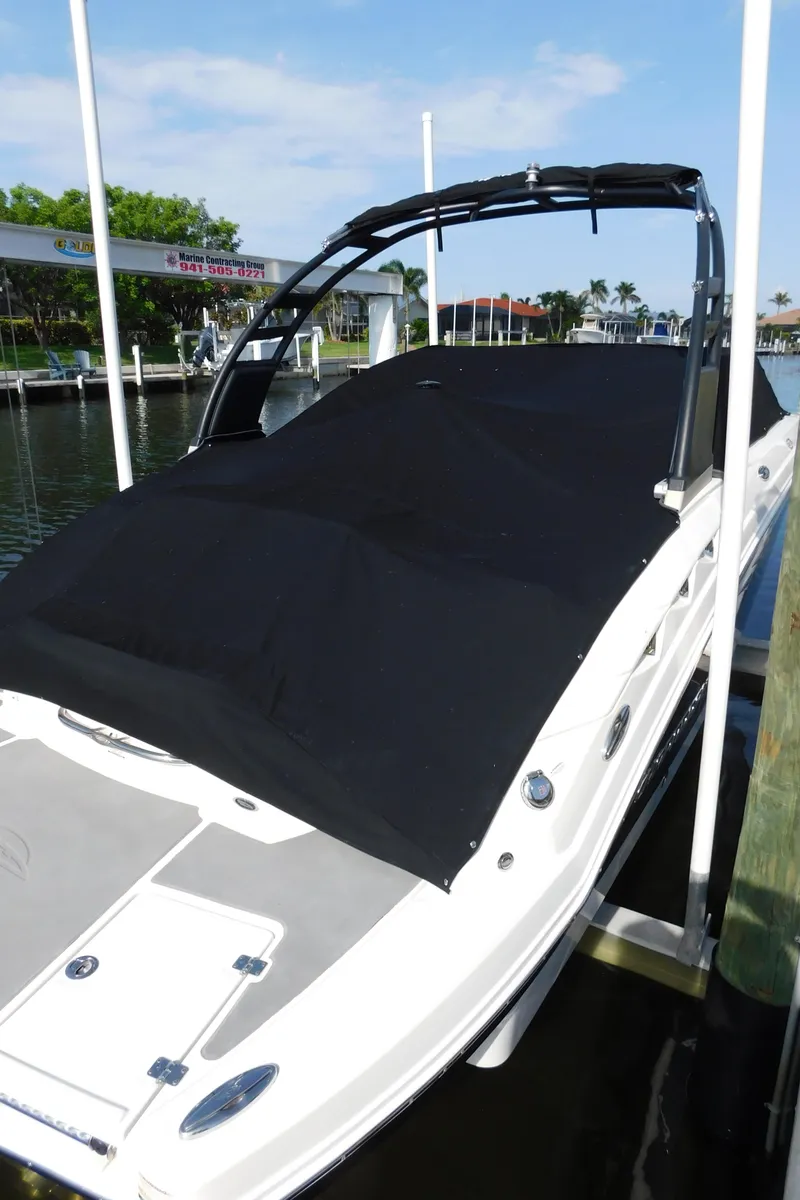 Slide: The Image of 2017 Chaparral 244 Sunesta boat with black cover docked at marina. - 5