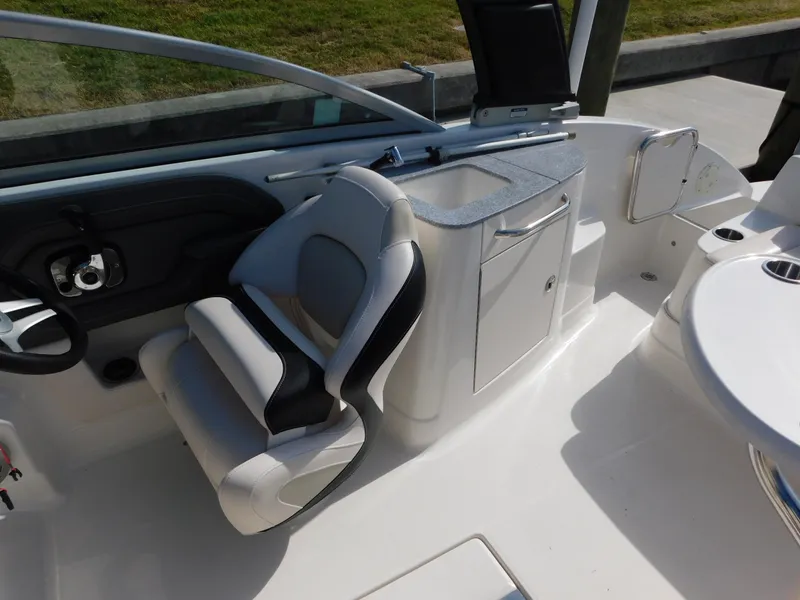 Slide: The Image of 2017 Chaparral 244 Sunesta boat interior with helm, seating, and storage area. - 8