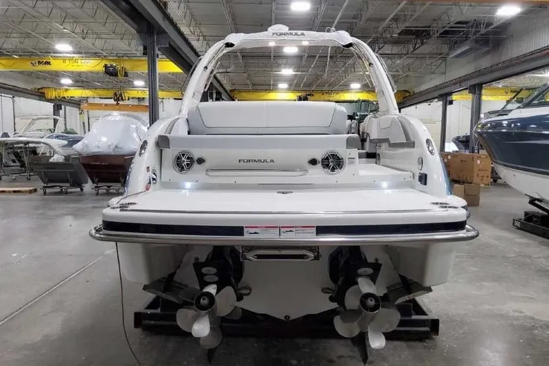 Slide: The Image of 2027 Formula 290 Bowrider boat in a warehouse, rear view showcasing dual propellers. - 7