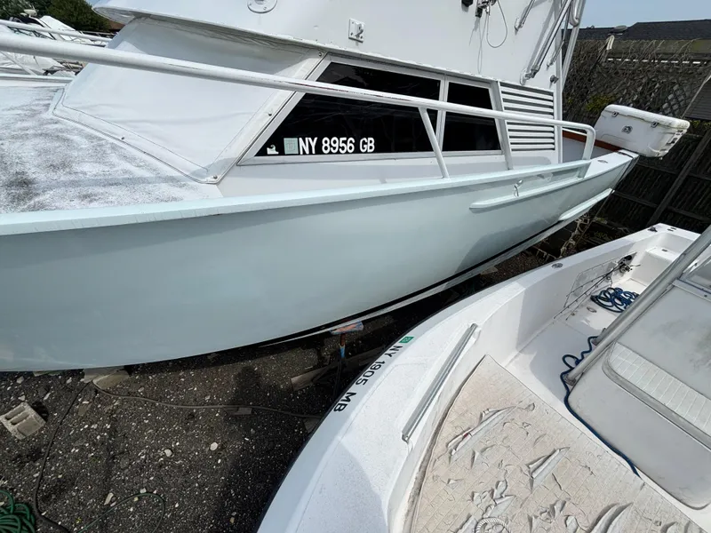 Slide: The Image of 1974 Striker Canyon Runner boat docked, displaying registration number NY 8956 GB. - 11
