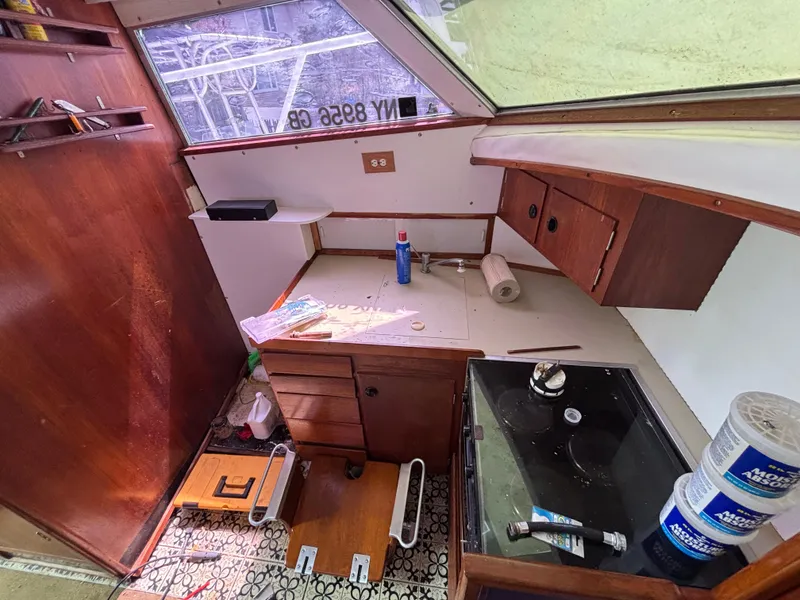 Slide: The Image of 1974 Striker Canyon Runner boat interior with wooden cabinets and kitchen area. - 16