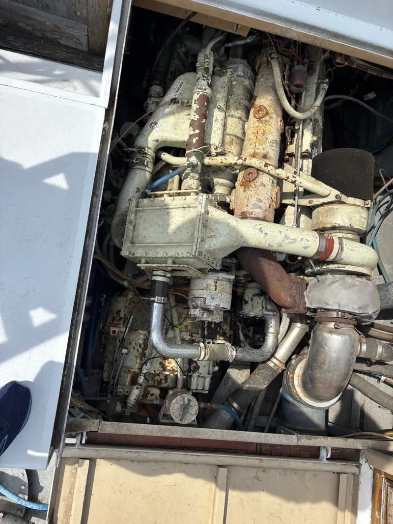 Slide: The Image of Engine compartment of a 1974 Striker Canyon Runner boat, showing mechanical components and piping. - 26