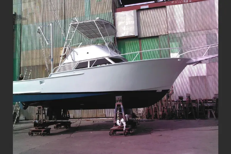 Slide: The Image of 1974 Striker Canyon Runner boat on stands in a shipyard, ready for maintenance. - 27