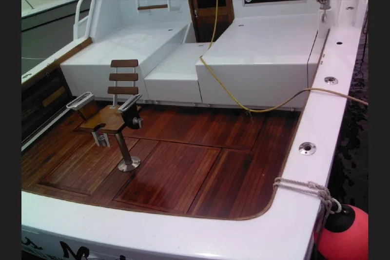Slide: The Image of 1974 Striker Canyon Runner boat deck with wooden flooring and fishing chair. - 29