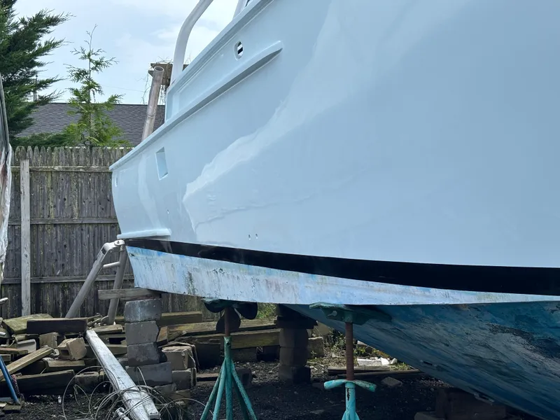 Slide: The Image of 1974 Striker Canyon Runner boat on stands, undergoing maintenance in a yard. - 5