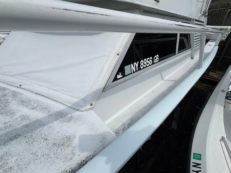 Slide: The Image of 1974 Striker Canyon Runner boat with registration NY 8956 GB, docked and partially covered. - 8