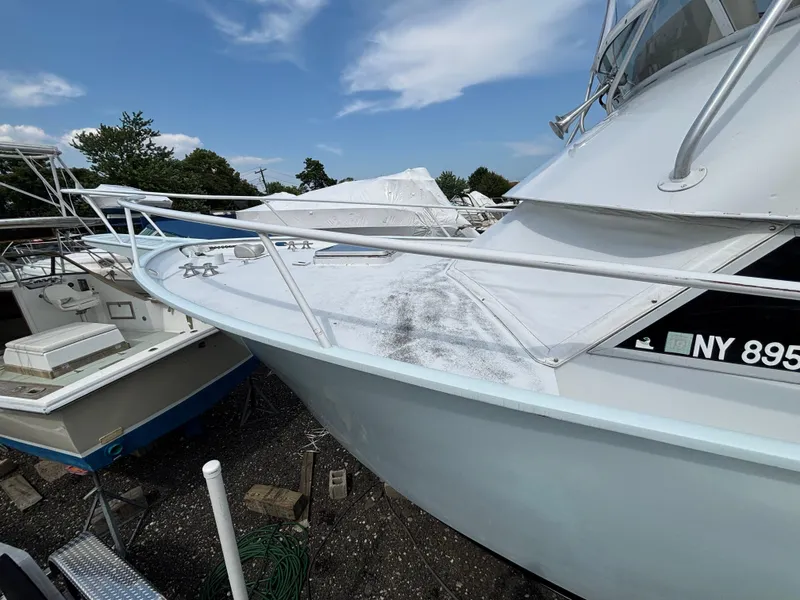 Slide: The Image of 1974 Striker Canyon Runner boat docked, showing deck and railing under a clear sky. - 9