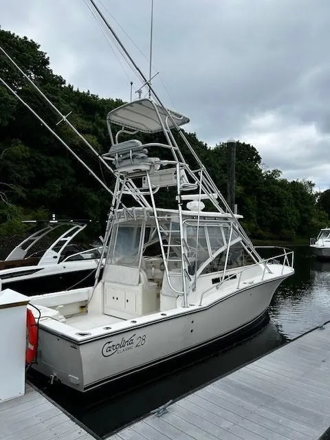 The Image of 2005 Carolina Classic 28 Express boat docked, featuring a tower and fishing equipment. - 0