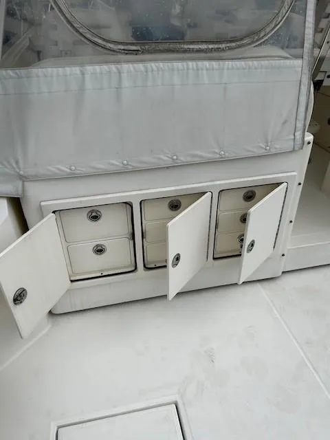 Slide: The Image of 2005 Carolina Classic 28 Express boat storage compartments with open doors. - 15