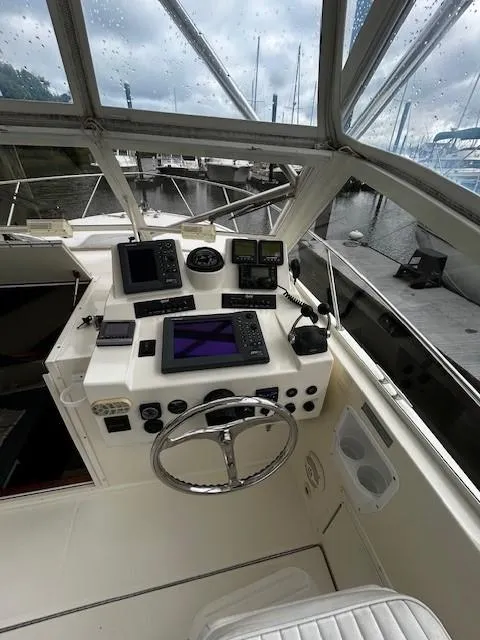 Slide: The Image of 2005 Carolina Classic 28 Express boat cockpit with navigation instruments and steering wheel. - 2