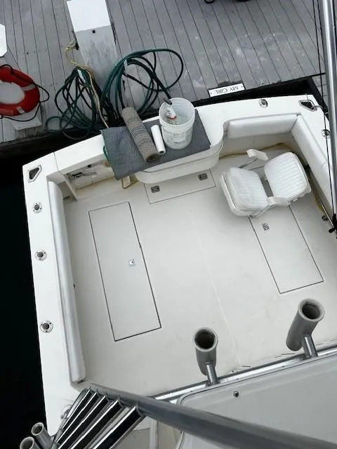 Slide: The Image of 2005 Carolina Classic 28 Express boat deck with seating and fishing rod holders. - 20