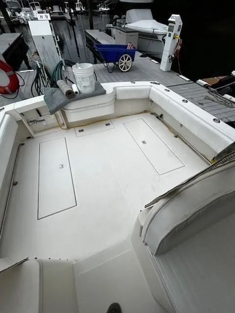 Slide: The Image of 2005 Carolina Classic 28 Express boat docked, featuring spacious deck and seating area. - 5