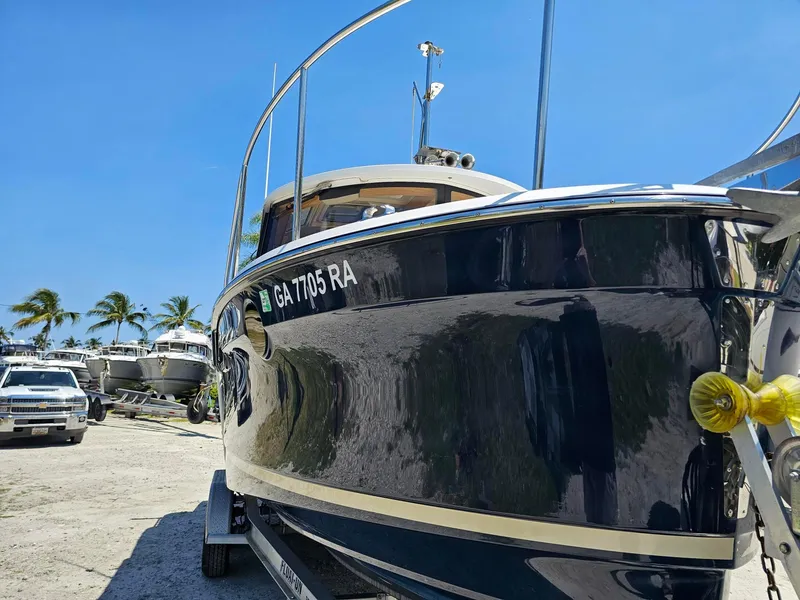 Slide: The Image of 2019 Ranger Tugs 23R boat on trailer, sunny day, palm trees in background. - 10