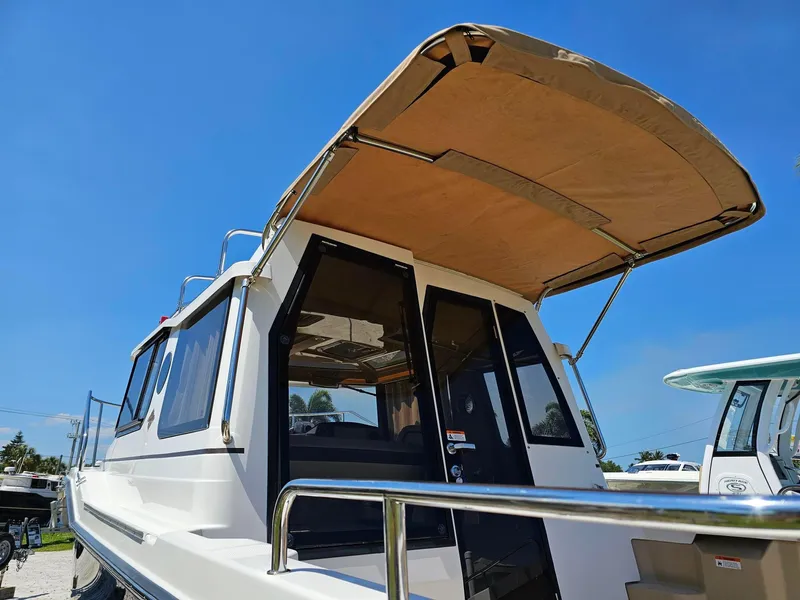 Slide: The Image of 2019 Ranger Tugs 23R boat with canopy under clear blue sky. - 11