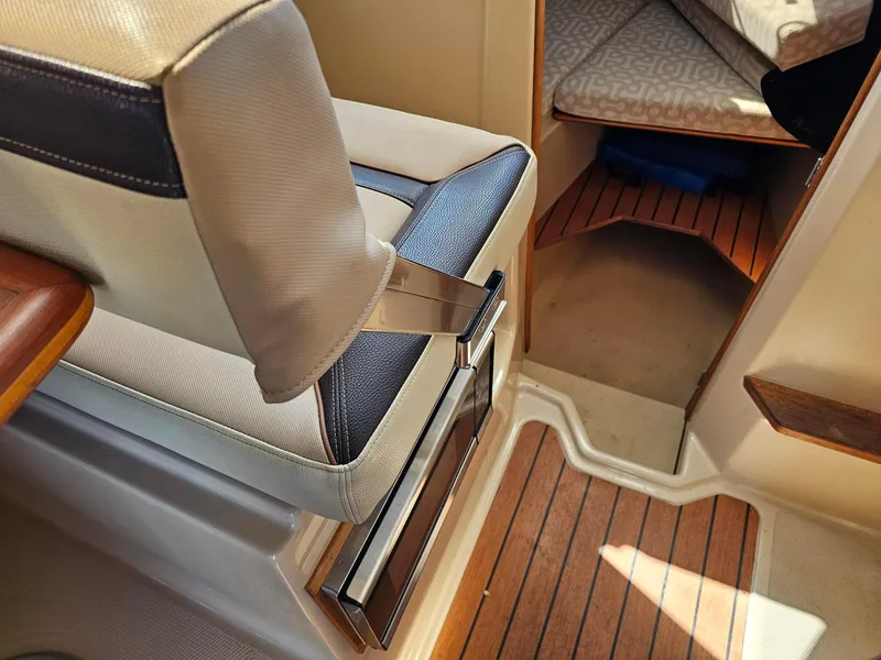Slide: The Image of 2019 Ranger Tugs 23R interior with cushioned seating and wood flooring. - 17