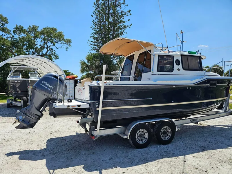 Slide: The Image of 2019 Ranger Tugs 23R boat on trailer with Yamaha outboard motor, parked outdoors. - 3