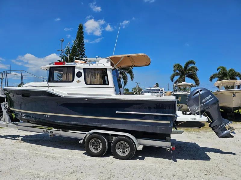 Slide: The Image of 2019 Ranger Tugs 23R boat on trailer, parked outdoors under clear blue sky. - 6