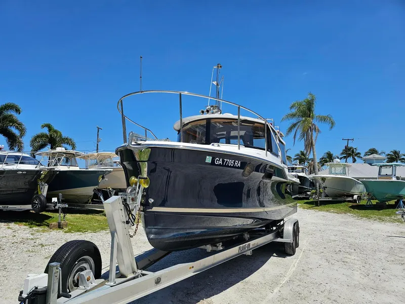 Slide: The Image of 2019 Ranger Tugs 23R boat on trailer, sunny day, palm trees in background. - 8