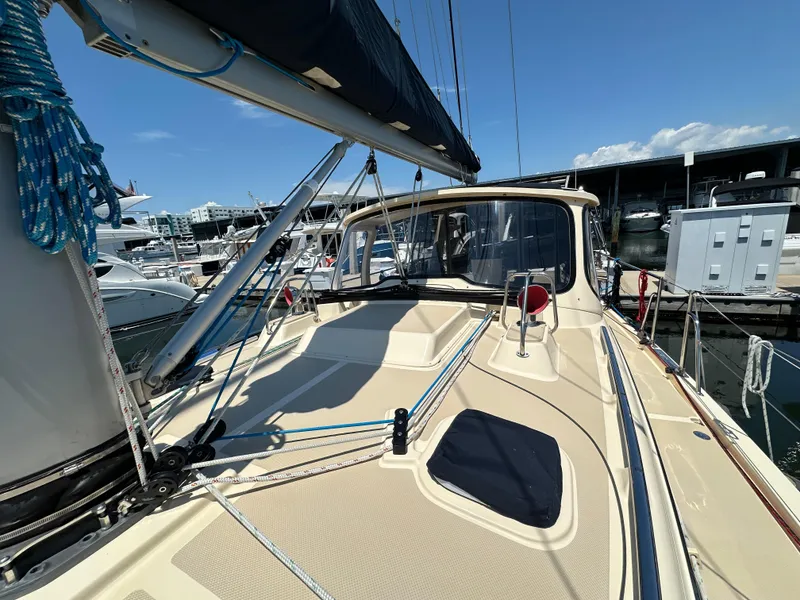 Slide: The Image of 2021 Island Packet 349 sailboat deck view at marina, showcasing rigging and cabin. - 11