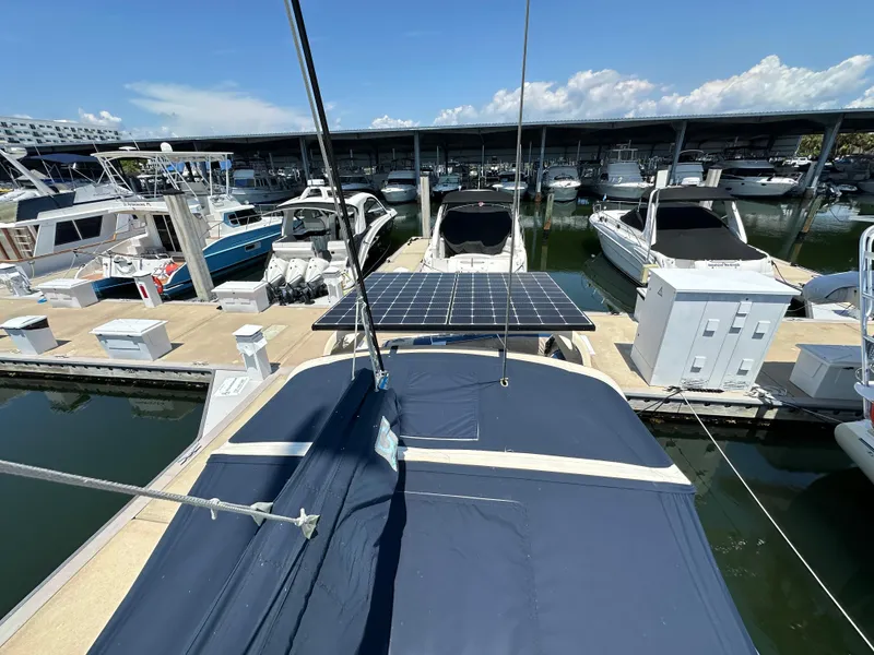 Slide: The Image of 2021 Island Packet 349 sailboat docked with solar panels, surrounded by other boats in marina. - 15