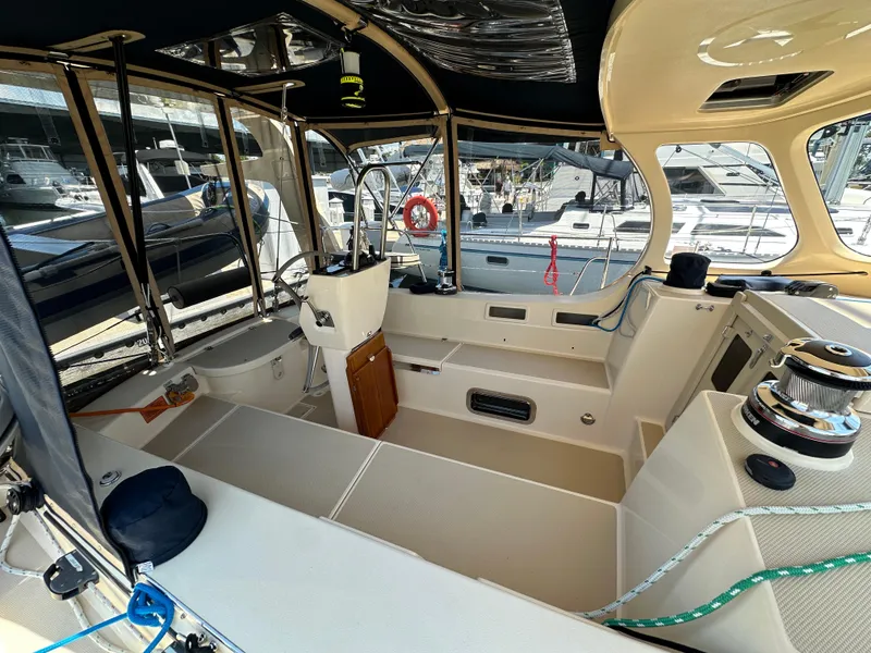 Slide: The Image of 2021 Island Packet 349 sailboat cockpit with helm, winches, and seating area. - 19