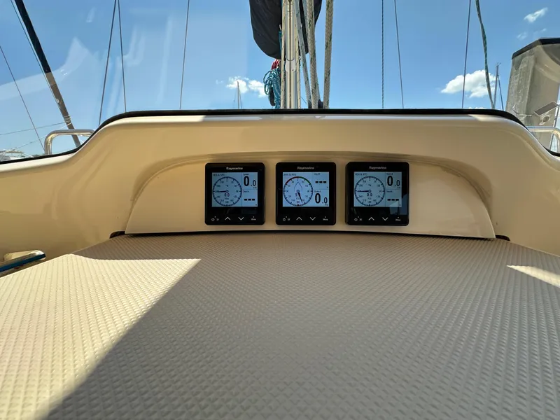 Slide: The Image of Island Packet 349 sailboat cockpit with Raymarine displays, 2021 model, under clear blue sky. - 25