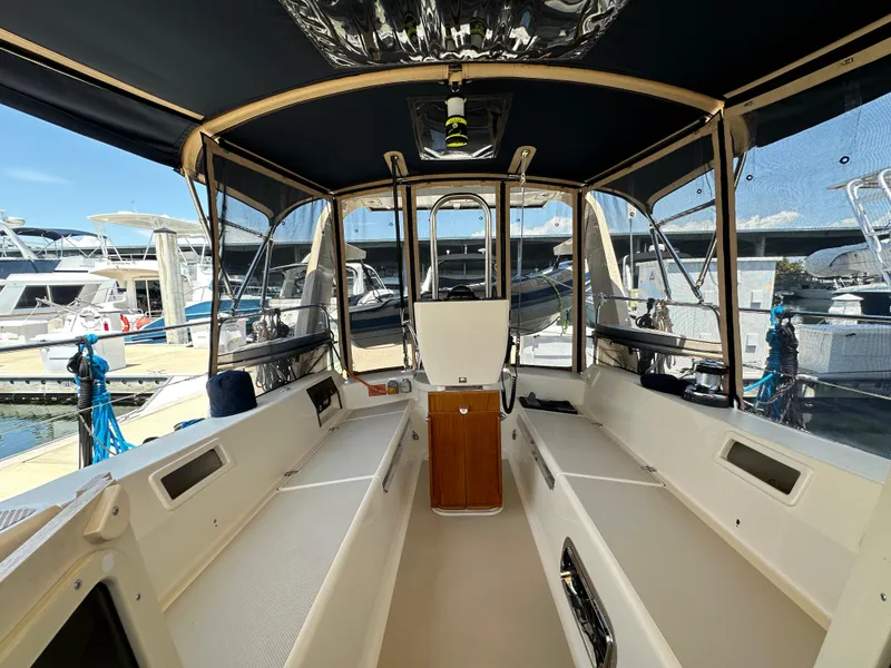 Slide: The Image of 2021 Island Packet 349 cockpit with canopy, docked at marina, showcasing spacious seating. - 28