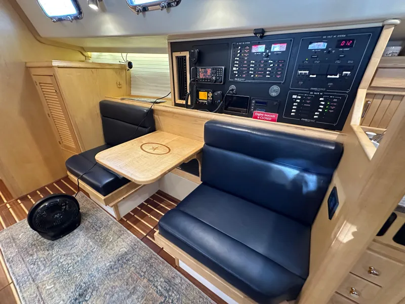 Slide: The Image of Interior of 2021 Island Packet 349 sailboat with navigation station and seating area. - 35