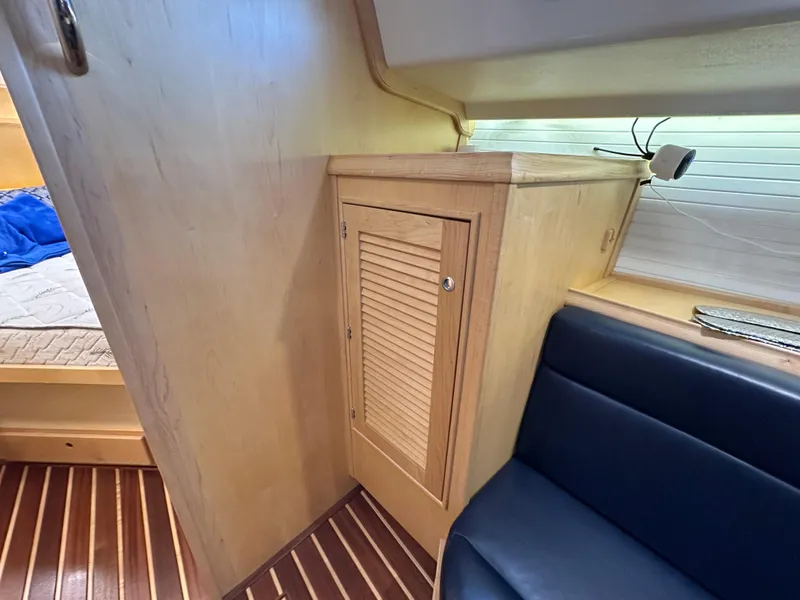 Slide: The Image of Interior of 2021 Island Packet 349 yacht, featuring wooden cabinetry and blue seating. - 39