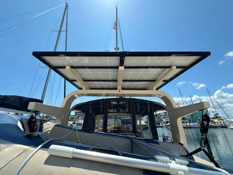 Slide: The Image of Island Packet 349 sailboat with solar panels, docked in a marina under a clear blue sky. - 4