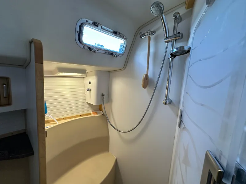 Slide: The Image of Island Packet 349 yacht bathroom with shower, 2021 model, featuring modern fixtures and porthole window. - 44