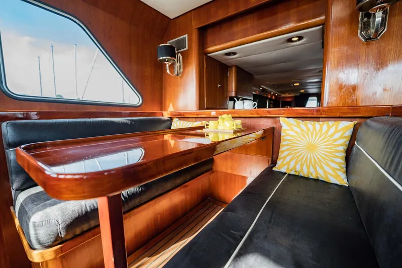 Slide: The Image of Luxurious 1985 Lowland yacht interior with wooden dining area and stylish seating. - 13