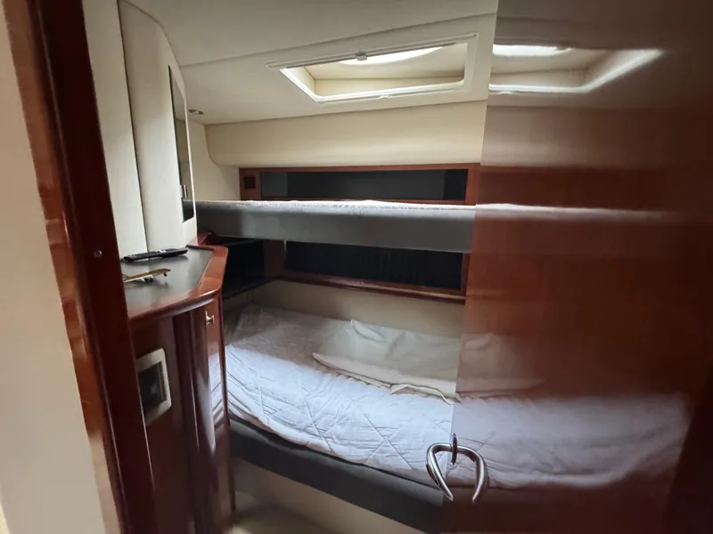 Slide: The Image of 2003 Sea Ray 500 Sundancer cabin with bunk beds and wooden interior. - 17