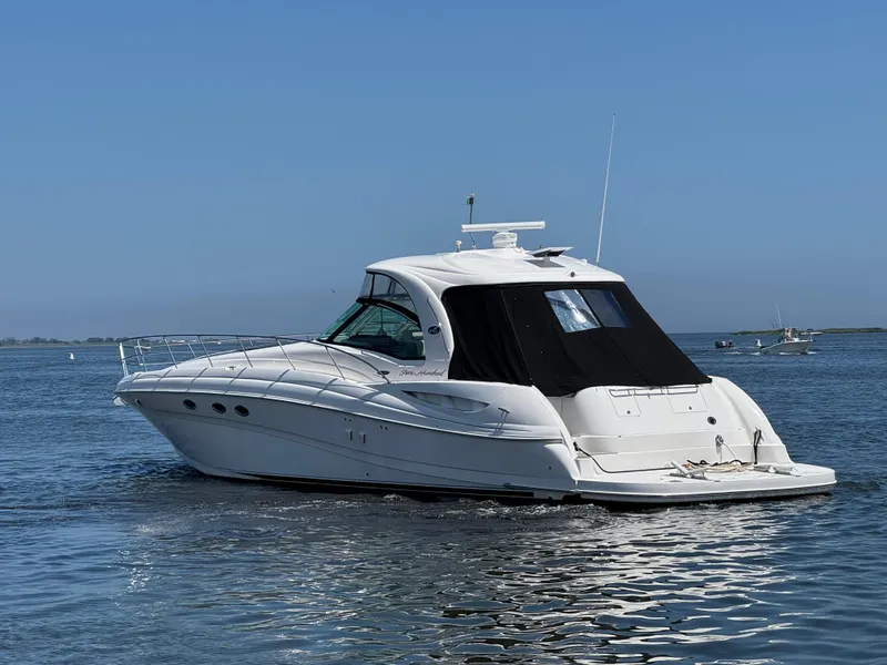 Slide: The Image of 2003 Sea Ray 500 Sundancer yacht cruising on calm waters under clear blue skies. - 2