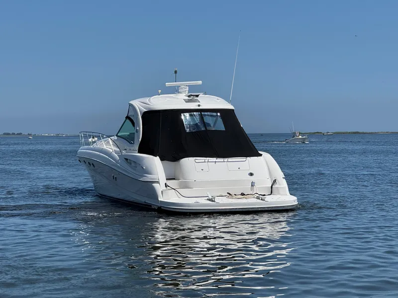 Slide: The Image of 2003 Sea Ray 500 Sundancer yacht on calm water under clear blue sky. - 4