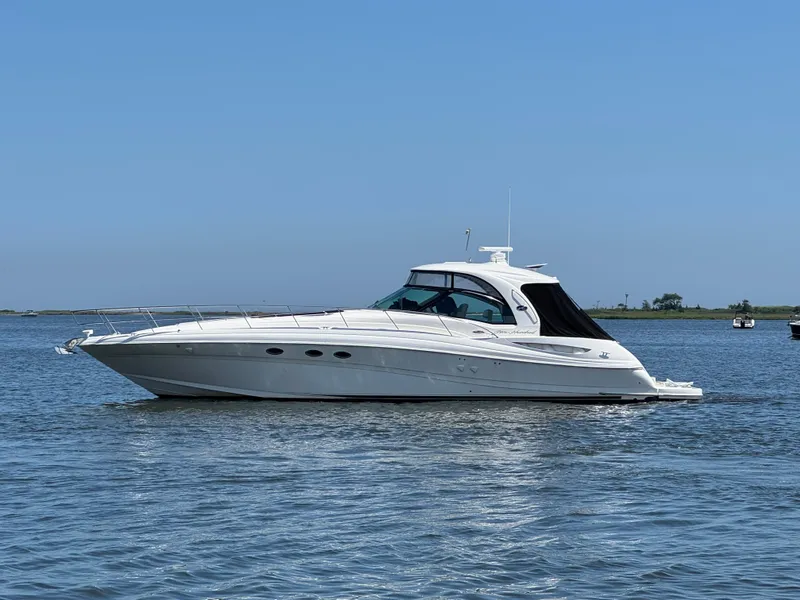 Slide: The Image of 2003 Sea Ray 500 Sundancer yacht cruising on calm waters under clear blue sky. - 6