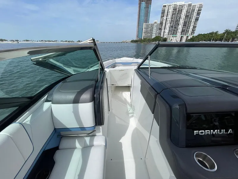 Slide: The Image of 2023 Formula 330 Crossover Bowrider OB on water, modern design, city skyline background. - 19