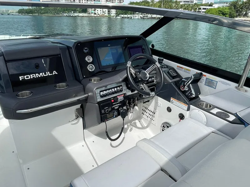 Slide: The Image of 2023 Formula 330 Crossover Bowrider OB helm with modern controls and navigation screens. - 24